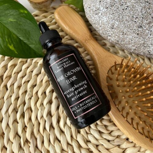 amber glass spray bottle with oil serum on the background with wooden brush