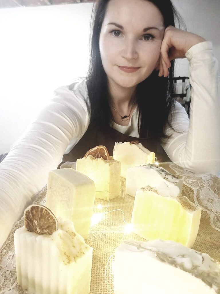 Tania and her array of natural soaps, accentuated by a softly lit garland.
